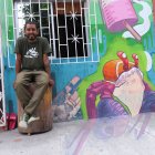Gabriel Peña, muralista guayaquileño, posando en una de sus pinturas en su sector.