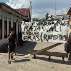 En esta imagen tomada el 8 de junio de 2020, un aldeano de pie junto a una pancarta lee su rechazo a la prueba rápida para los miembros de su comunidad en medio de la preocupación por el coronavirus COVID-19, en Makassar, South Sulawesi. Decenas de indonesios han sido arrestados por arrebatar a las víctimas de COVID-19 de los hospitales en un intento por enterrarlos de acuerdo con las costumbres locales en la nación de mayoría musulmana, dijo la policía.