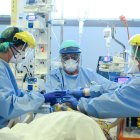 Member of the medical staff take care of a patient infected by the novel coronavirus, at the COVID-19 division at the ASST Papa Giovanni XXIII hospital in Bergamo, on April 3, 2020. Italy"s three-week lockdown to stop the spread of COVID-19 has been extended through at least mid-April and its economy is expected to suffer its biggest peacetime shock since World War II. / AFP / Piero CRUCIATTI

 ITALY-VIRUS-HEALTH