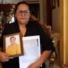 Elsa Maldonado sostiene un retrato de su madre y los papeles de defunción.