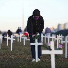 A demonstrator places flowers on a cross during a protest against Brazilian President Jair Bolsonaro and in honour of the people who died of COVID-19 in which 1000 crosses were placed in front of the National Congress in Brasilia, on June 28, 2020, amid the novel coronavirus pandemic. - The pandemic has killed at least 495,288 people worldwide, including more than 55,000 in Brazil, since it surfaced in China late last year, according to an AFP tally at 1900 GMT on Saturday, based on official sources. (Photo by Sergio LIMA / AFP)