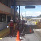 Usuarios esperan encolumnados por un turno de atención en elsector del peaje de la avenida Rumiñahui, de Quito.