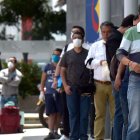 Un grupo de hombres hace fila para entrar a un banco en Bogotá, Colombia.