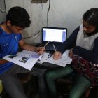 En la cooperativa de vivienda Sergio Toral, del noroeste de Guayaquil, dos hermanos comparten una computadora para sus clases.