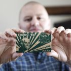 Mayor Wayne Fournier holds $25 in wooden money, in Tenino, Washington on July 10, 2020. - Tenino had become a ghost town, and small businesses were struggling to survive amid the coronavirus pandemic, so local officials revived an unconventional idea from the last century: print its own currency on planks of wood. (Photo by Jason Redmond / AFP)