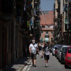 BARCELONA. Dos personas transitan por una calle, ayer, tras el pedido de las autoridades de no salir de casa.