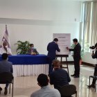 El presidente Lenín Moreno observa la firma del acuerdo entre el ministro Martínez y el representante de Herdoiza Crespo, Javier Freire.