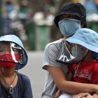 A woman waits with her children at a makeshift rapid testing centre as Vietnam records a rise in cases of the COVID-19 coronavirus in Hanoi on July 31, 2020. - Vietnam has recorded 45 news cases of COVID-19 -- its highest single daily tally since the pandemic began -- as an outbreak in the resort city of Danang erodes the country"s efforts to stay virus-free. (Photo by Nhac NGUYEN / AFP)
