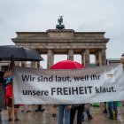Protestantes en Berlín exponen un cartel que lee: "Alzamos la voz, porque ustedes nos roban la libertad".
