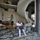 Una mujer se sienta frente a un edificio dañado por la explosión masiva en Beirut, Líbano. Al menos 100 personas murieron y más de 4.000 resultaron heridos.