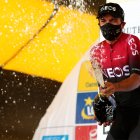 El ecuatoriano Richard Carapaz festeja con champaña en el podio tras el primer lugar en la tercera etapa.