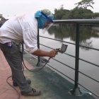 Obreros dan mantenimiento a las barandas del Malecón Universitario.