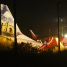 First responders inspect the wreckage of an Air India Express jet, which was carrying more than 190 passengers and crew from Dubai, after it crashed by overshooting the runway at Calicut International Airport in Karipur, Kerala, on August 7, 2020. - At least 14 people died and 15 others were critically injured when a passenger jet skidded off the runway after landing in heavy rain in India, police said on August 7. (Photo by Favas JALLA / AFP)