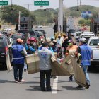 Los comerciantes promocionan sus productos a los viajeros que cruzan el peaje.