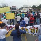 Con pancartas alusivas a sus reclamos, los funcionarios y trabajadores de los GADs bloquearon la carretera, este miércoles 13 de agosto de 2020.
