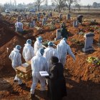 Johannesburgo. Los miembros de una familia vestidos con trajes se seguridad llevan los restos de uno de sus ancianos que murió por la COVID-19, el pasado 24 de julio.