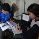 En una vivienda de la cooperativa Sergio Toral, dos hermanos comparten una computadora para recibir las clases no presenciales del sistema educativo público.