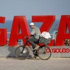 Gaza. Un palestino se traslada en bicicleta cerca de la playa.