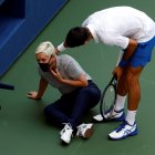 El tenista serbio Novak Djokovic intenta ayudar a una juez de línea después de golpearla con una bola en la garganta.