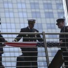 Bomberos se preparan para izar la bandera estadounidense en la conmemoración del año pasado.