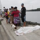 Tobby, mascota de Jordan David Perlaza Velásques, gime y ladra por la muerte de su amo. Al fondo familiares y vecinos lloran por el suceso.
