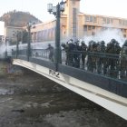 Miembros de carabineros observan a un manifestante que se encuentra inconsciente luego de caer en el río Mapocho.