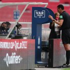 El árbitro Wilmar Roldán consulta en la pantalla del VAR para determinar el primer penal a favor de Uruguay, en el juego contra Ecuador