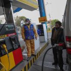 Empleados atienden en un surtidor de gasolina hoy en La Paz (Bolivia).