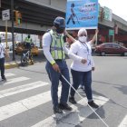 El agente de ATM, Miguel Saltos, se pone en el lugar de una persona con discapacidad al vendar sus ojos y cruzar la calle.