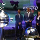El director de competiciones de Clubes Conmebol, Frederico Nantes (c), posa junto a los trofeos de la Copa Libertadores y Sudamericana.
