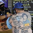 El pizzero Guillermo Rodríguez, bautizado en la iglesia maradoniana, muestra los tatuajes en su espalda que representan a la leyenda del fútbol argentino Diego Maradona, en Merlo, provincia de Buenos Aires.