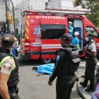 La víctima yace en el piso entre socorristas y policías que acudieron al lugar del crimen.