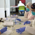 Unos técnicos de laboratorio empaquetan en bolsas de plástico las pruebas del coronavirus realizadas en San Juan.