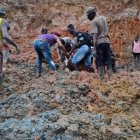 Pobladores ayudan a rescatar los cuerpos sumergidos bajo el lodo.