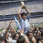 El argentino Diego Maradona en uno de los momentos cumbres de su carrera levantando el trofeo en el Mundial de México 86, gesta ecuménica donde además de marcar cinco goles, fue el cerebro de un conjunto albiceleste que celebró su segundo cetro a ese nivel.