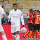 Dentinho de Shakhtar celebra el gol con sus compañeros mientras los jugadores del Real Madrid se lamentan.