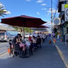 Comensales disfrutan de la gastronomía en mesas al aire libre