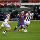 Lionel Messi, ofensivo de Barcelona, intenta eludir la marca de dos rivales del Levante.