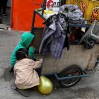 Fotografía de archivo donde se observan niños que acompañan a sus padres a trabajar con una carreta de productos vegetales en una calle de Quito.
