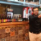 Juan Zurita, sostiene la cerveza de su marca Beerman y exhibe otras artesanales de otras marcas.