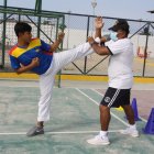Entrenamientos. Kember Beltrán, junto a su entrenador Jorge Vargas, durante una jornada en la cancha de uso múltiple de su barrio, sitio donde improvisa sus prácticas diarias.