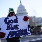 Dios bendiga a América entre los carteles que se puedan leer fuera del Capitolio.