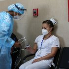 Una enfermera revisa el estado de su colega Cristina Chango recibe luego de ser vacunada contra la covid-19 en el Hospital Centinela Pablo Arturo Suárez hoy, en Quito (Ecuador).