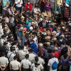 Migrantes hondureños se arrodillan para orar frente a los policías guatemaltecos, el 17 de enero de 2021.