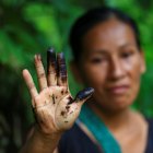 Una indígena de la comunidad de Amarumesa muestra en su mano residuos de petróleo en la Amazonía ecuatoriana.