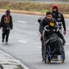 Ciudadanos venezolanos, uno de ellos con discapacidad, transitan por una carretera cercana a Quito (Ecuador).
