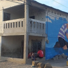 Obras. En la primera pared se muestra la cara de la Valdivia y en la segunda figura, uno de los artistas plasma la figura de un niño, una canoa y el mar.