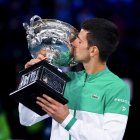 Novak Djokovic besa el trofeo luego de hacer suyo por novena ocasión el Abierto de Australia.