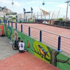 Felipe Arroba pinta un árbol en un mural en el Malecón 2000, junto al pintor Andy Son.