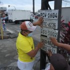 VENDEDORES AMBULANTES ENCONTRARON PLACAS DE LOS CARROS CAIDOS EN LA AVENIDAS Y BUSCARON LUGARES VISIBLES PARA QUE PUEDAN RECONOCER LAS PLAS POR EL FUERTE AGUACERO QUE SOPORTO GUAYAQUIL 9 DE MARZO DEL 2021 GUAYAQUIL-ECUADOR